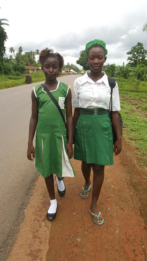 Two girls walk to school in Sierra Leone.