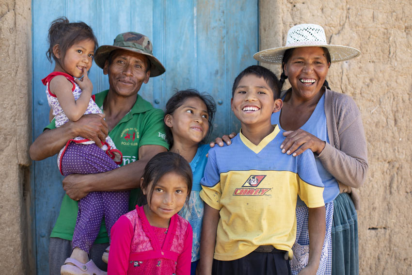 A family stands outside their home in Bolivia.