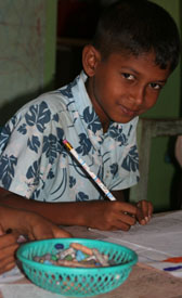 Image of a child drawing while attending a Child Centered Space in Hambantota