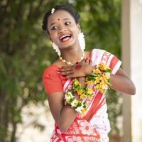 A girl in India wearing traditional dress sings and dances.