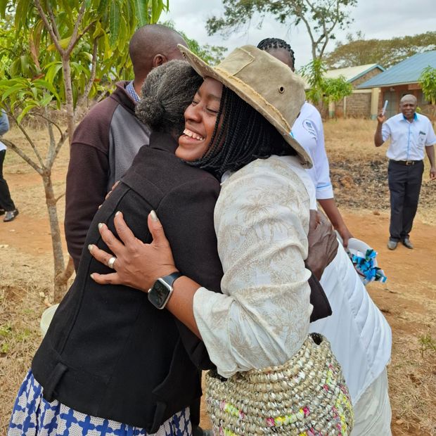 An American woman visiting a ChildFund program hugs a local partner staff member in Kenya.