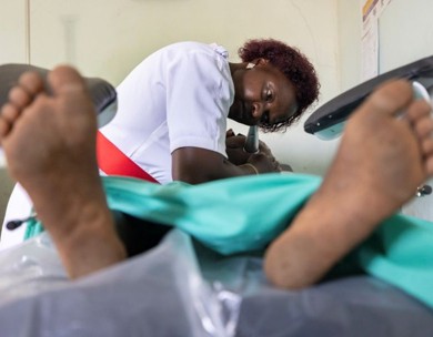 An expectant mother lays on a bed in a delivery room.