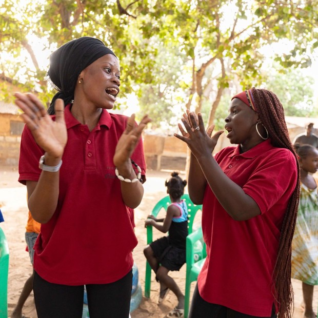 Women smiling and clapping outside
