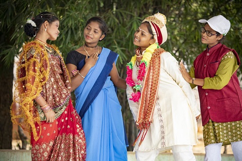 A group of young women dressed up performing a play in India about child marriage.