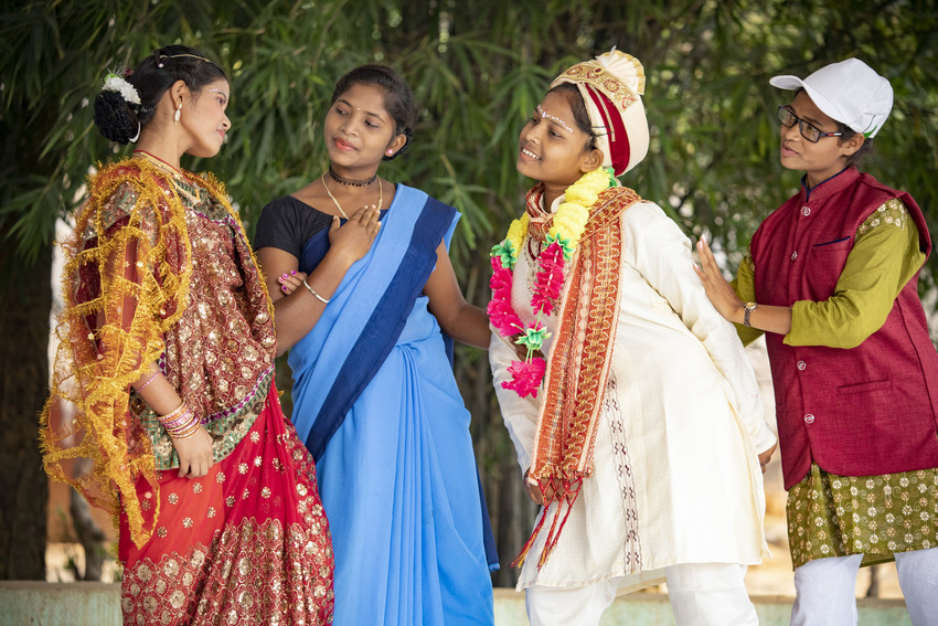 A group of costumed teenage girls perform a street play in India.