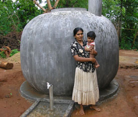 Image of a mother and child standing in front of a water storage tank