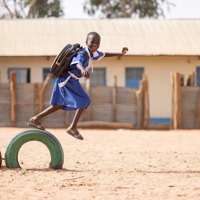 smiling girl plays at school