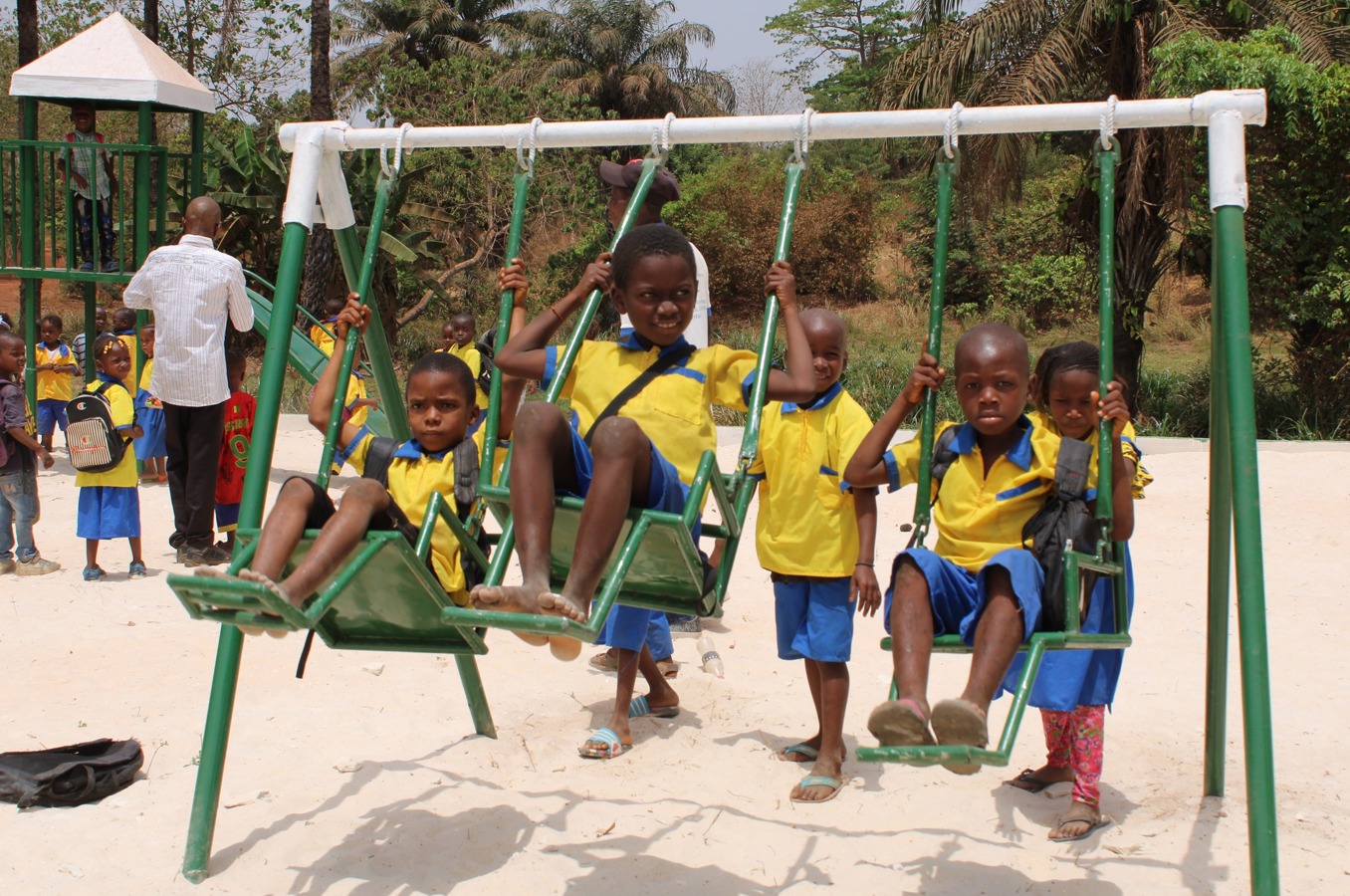 Children swing on a swing set in Guinea.