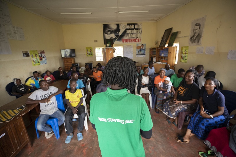 A peer educator talks to a group of people in Zambia.