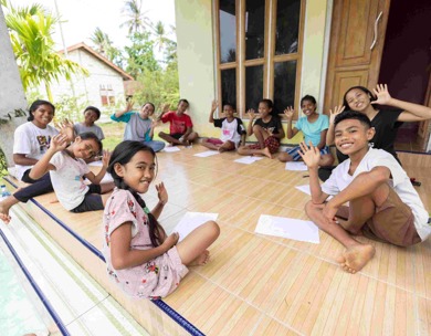 A group of children and youth participating in a ChildFund Youth Circle meeting on a porch in East Nusa Tenggara, Indonesia.