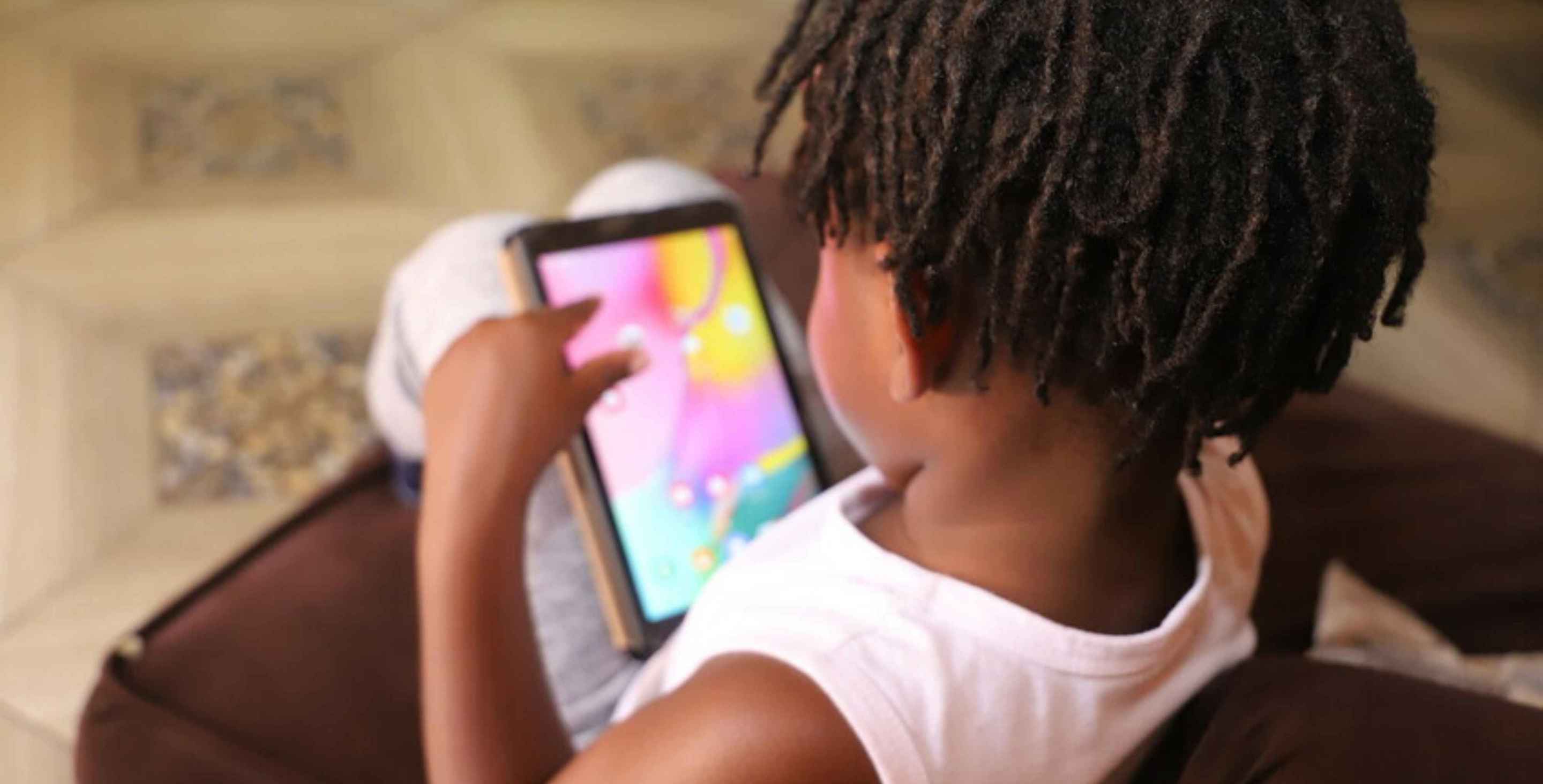 Jimmy, age 5, with his dad's tablet, seen from behind