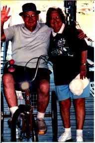 Husband and wife stand smiling at the camera