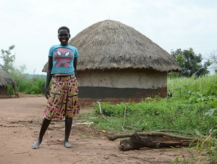 Teenage girl blue shirt smiling standing outside in Uganda. 