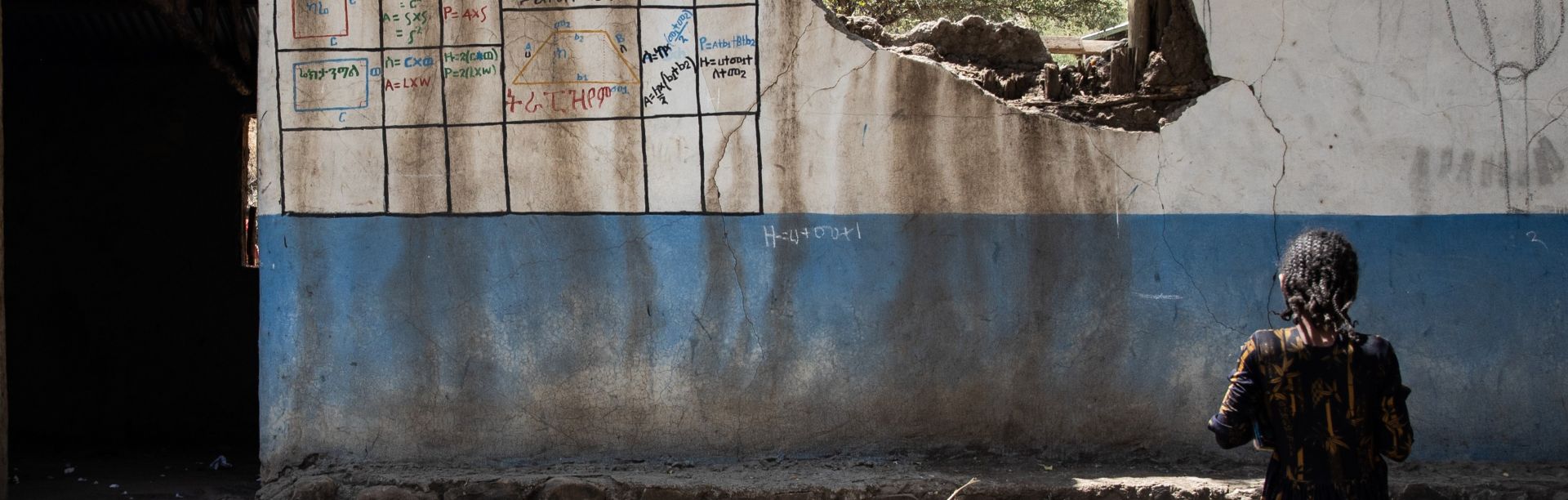 Fourth-grade student Haimanot, 14,  standing outside one of the classrooms that was bombed.  After more than two years of war, calm has returned to Afar, Amhara and Tigray regions in northern Ethiopia.  Schools are reopening and children are trickling back to class. One primary school in Kobo District, Amhara Region, finally reopened its doors to children last November 2022, after closing in July 2021.  Unfortunately, the school which was occupied and used as a camp by both warring parties (government forces and the Tigray People's Liberation Front rebels), at different times during the war, is now in ruins. As the warring parties fought and exchanged heavy gunfire, the school’s facilities were destroyed.