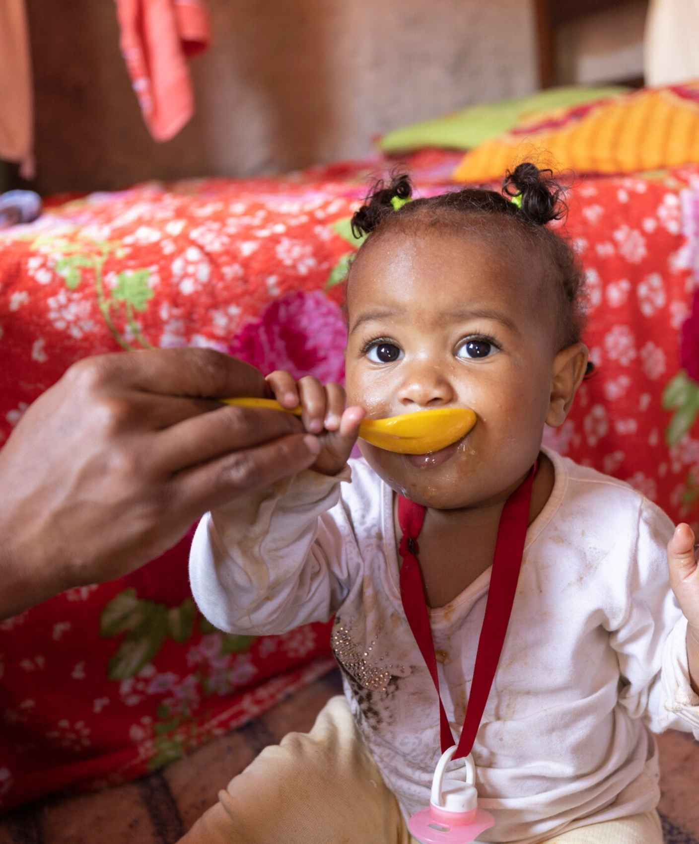 A young girl being spoonfed.