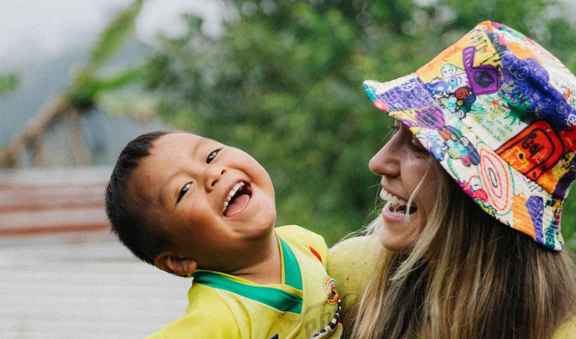 Lauren Daigle smiles while holding young sponsored child