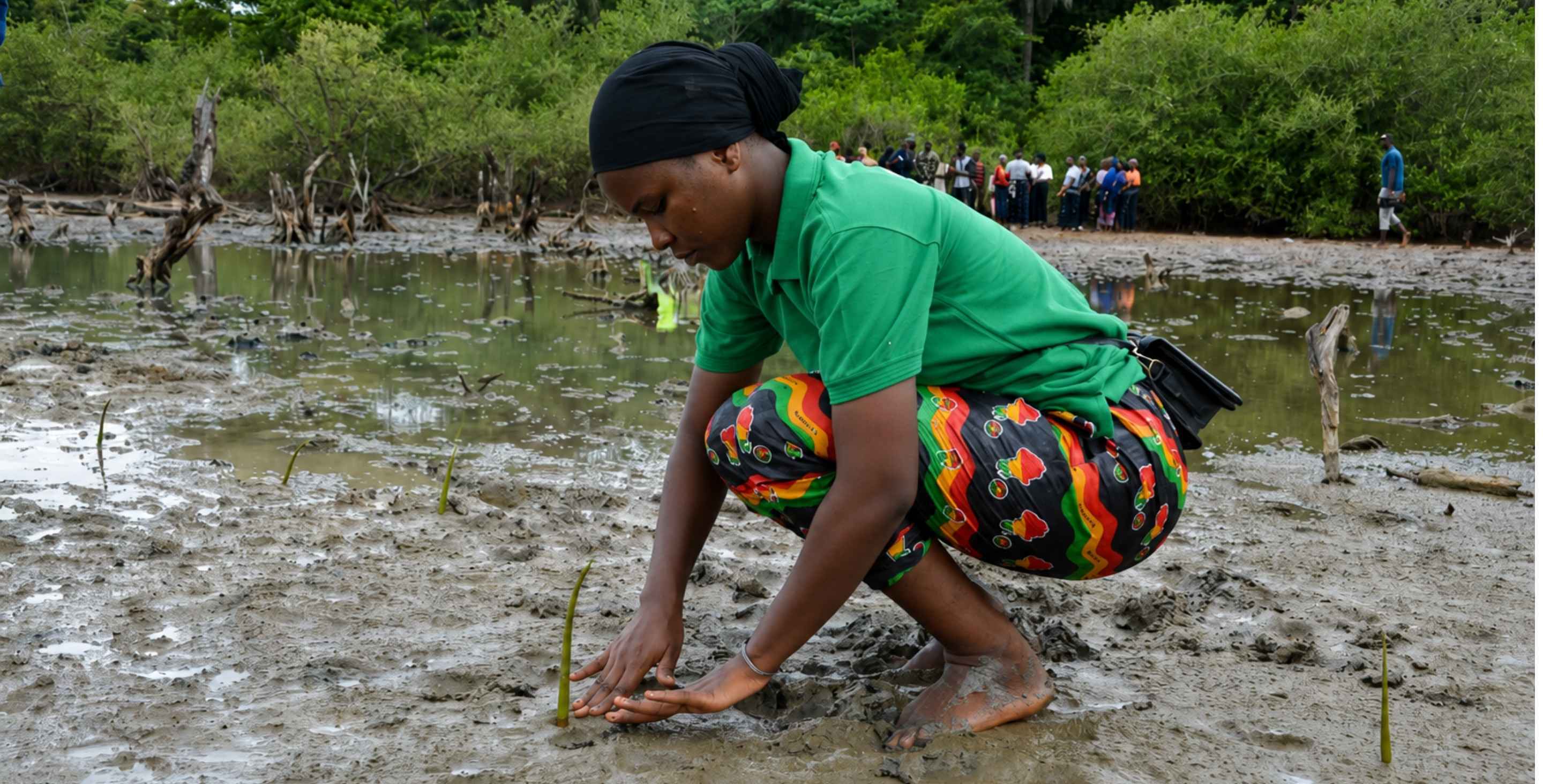 A youth climate activist plants a green mangrove seedling in a degraded coastal wetland, with a community group and palm trees visible in the background.