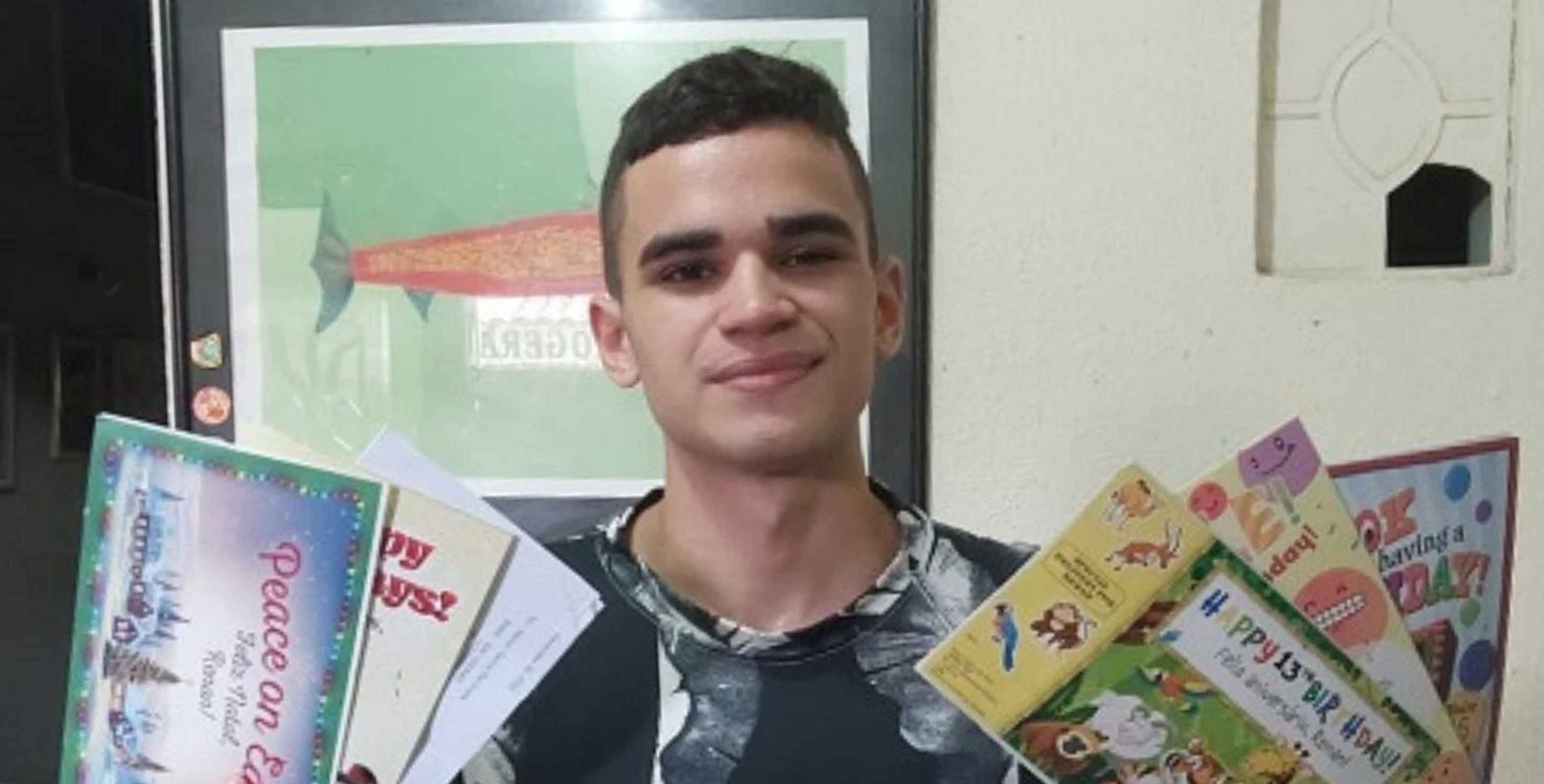 young man holding letters and cards from his sponsor