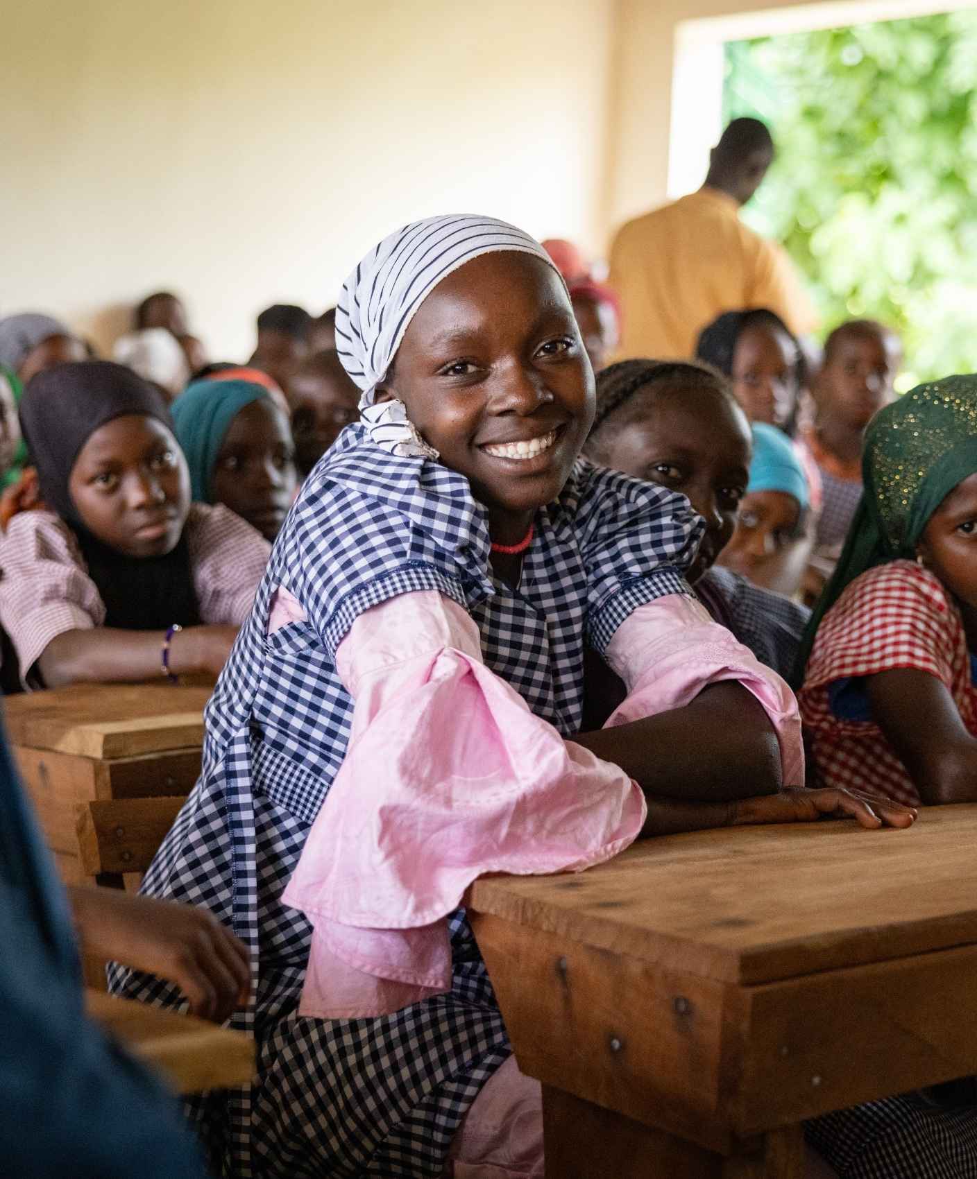 A group of girls sit at desks in a classroom.