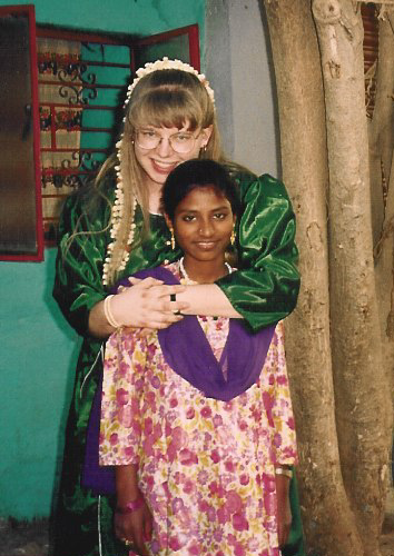 Angie stands behind her first sponsored child, Asma, giving her a hug.
