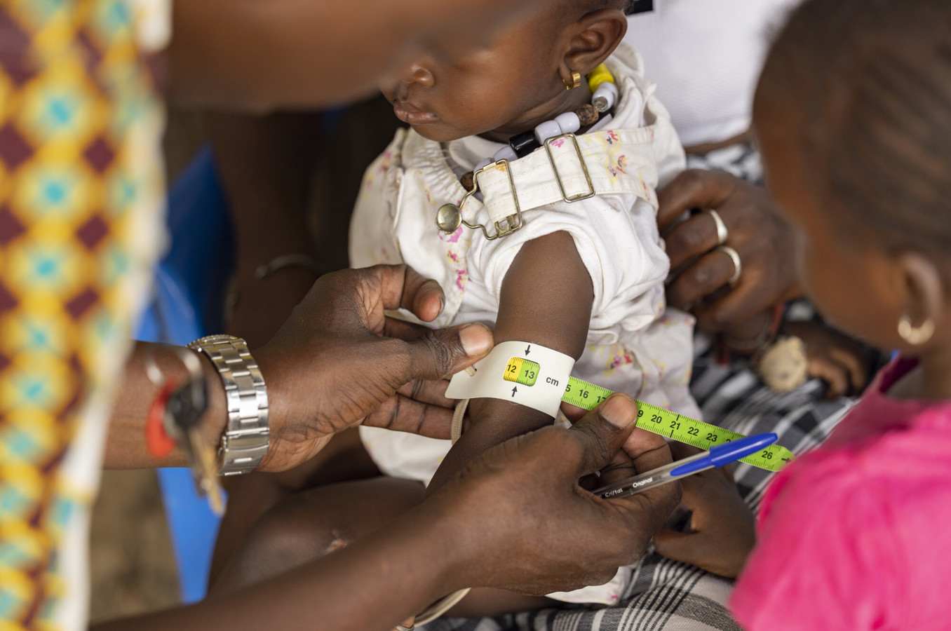 A baby's arm is measured by a nurse in Senegal.
