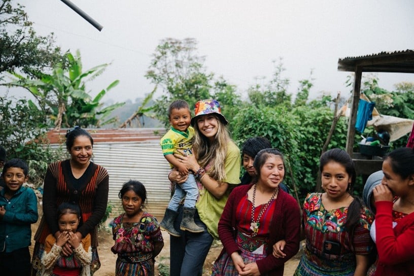Artist Lauren Daigle surrounded by sponsor children.