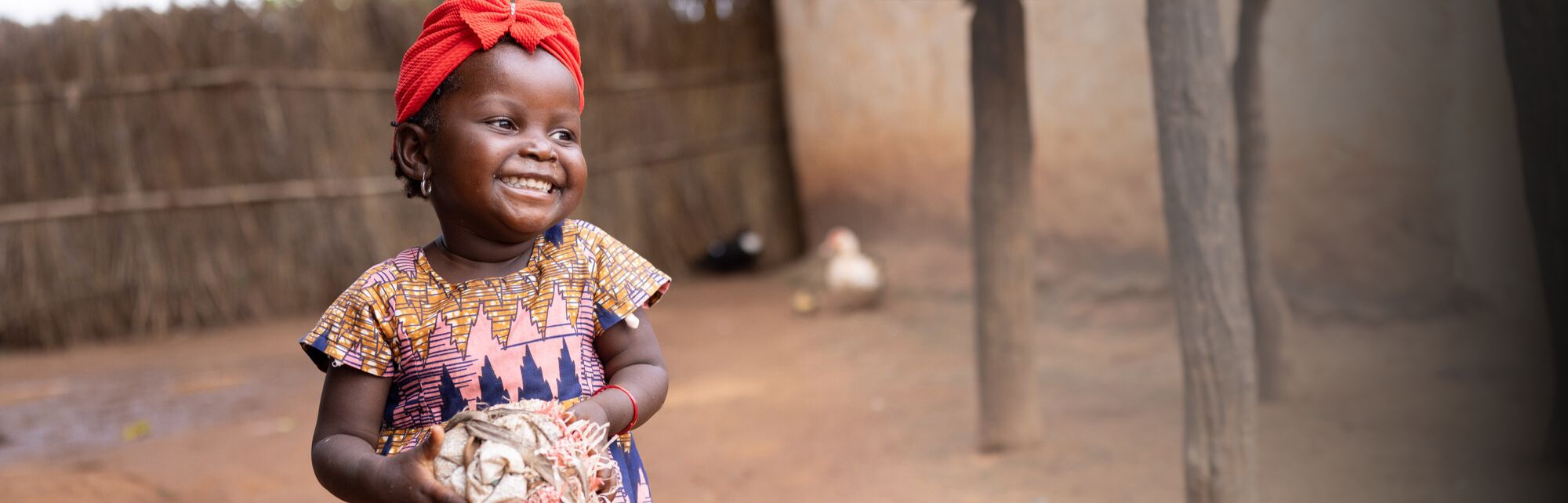 Young girl with a red head scarf smiling