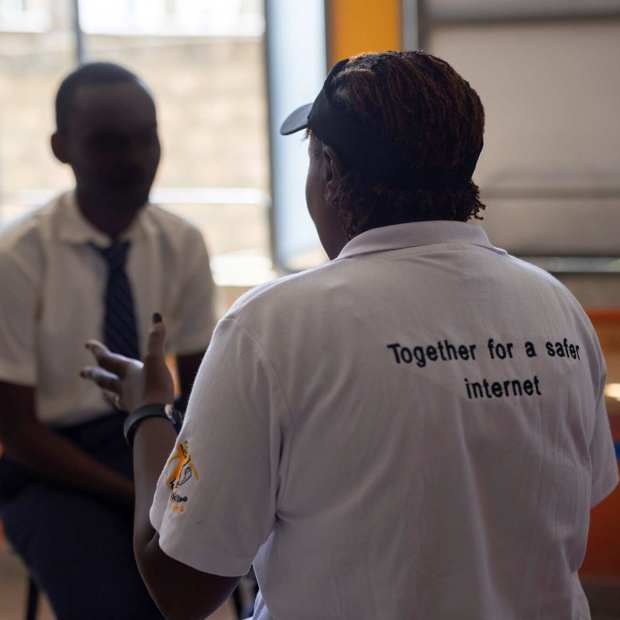 Counselor from Childline Kenya provides support to a teenage boy during a Safe CLICS counseling session in a classroom setting in Mombasa, Kenya.