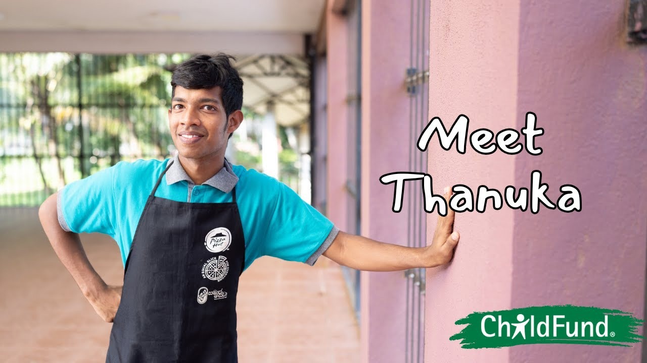 Thanuka smiles outside his job in uniform