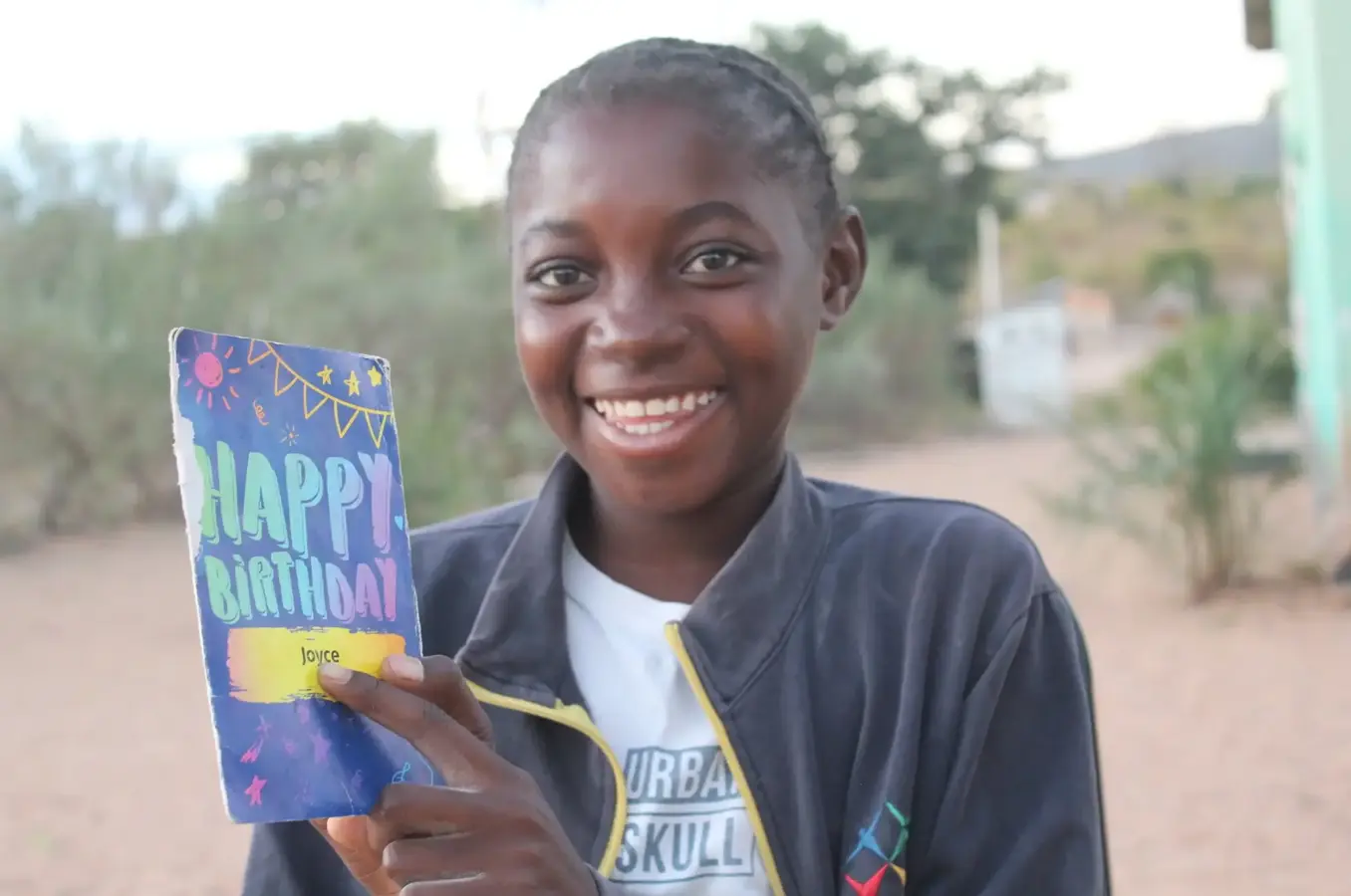 Girl smiles with birthday card
