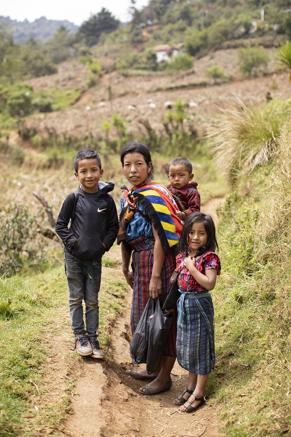 Family stands together, smiling, in Guatemala.