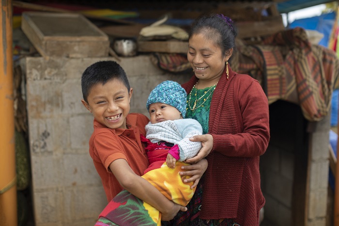 Family stands together, smiling, in Guatemala.