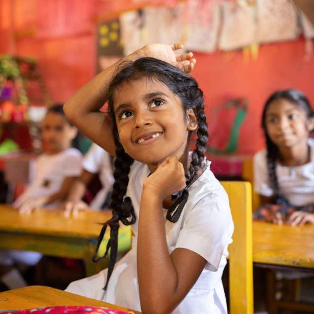 primary school girl in Sri Lankan classroom, raising her hand