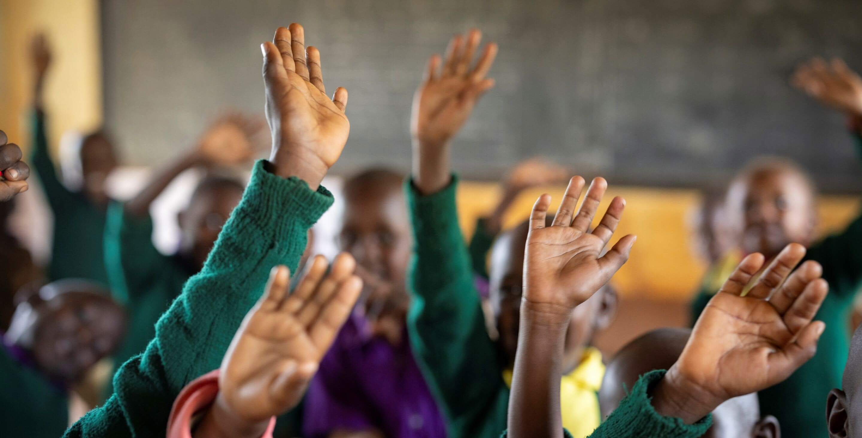 A bright, renovated classroom in Kajiado County, Kenya, featuring new windows, blackboards, and cemented floors.
