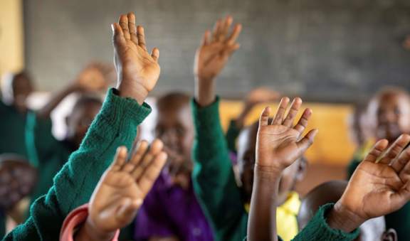 A bright, renovated classroom in Kajiado County, Kenya, featuring new windows, blackboards, and cemented floors.
