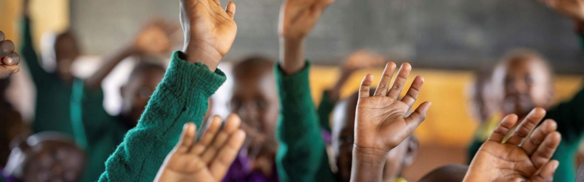 A bright, renovated classroom in Kajiado County, Kenya, featuring new windows, blackboards, and cemented floors.