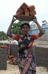 Image of an Indian woman carrying bricks to help rebuild schools Image of an Indian woman carrying bricks to help rebuild schools