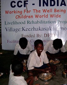 Image of men and women eating breakfast in the Tsunami Naga settlement