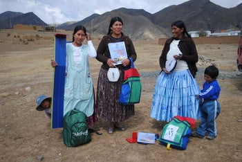 A group of three Guide Mothers and two young children stand outdoors in Bolivia. A group of three Guide Mothers and two young children stand outdoors in Bolivia.