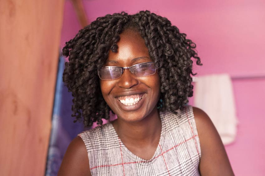 Beth, 21, shown here braiding a customer’s hair, received a ChildFund scholarship to study hairdressing, as well as startup capital to open a salon.