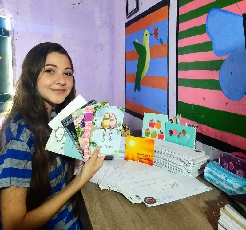 A Brazilian teen holds greeting cards sent to her from a sponsor.