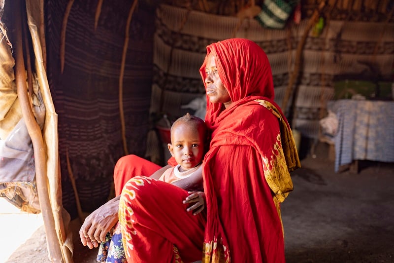 Mother and child sit together in a hut in Kenya.