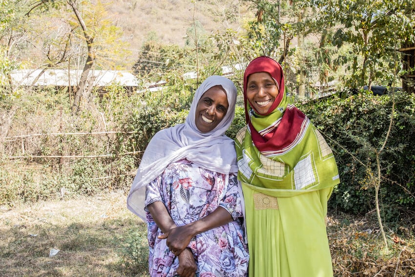 Two women in Ethiopia smile at the camera.