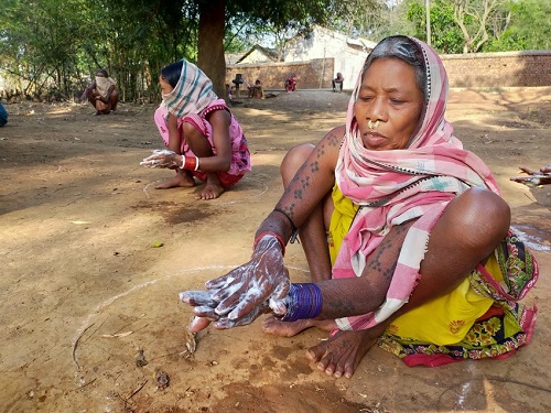 Group of women washes hands outside in India